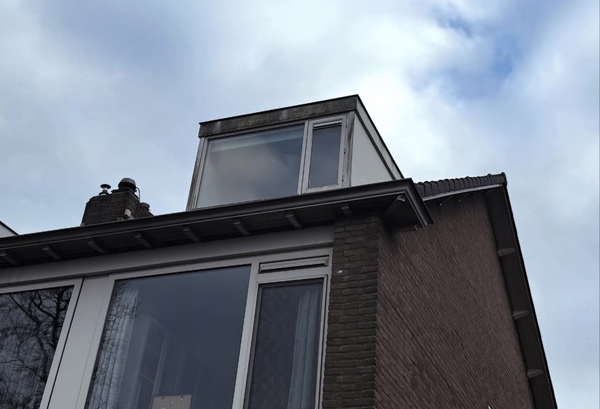 Gereinigde dakkapel met schone kozijnen en dakgoot